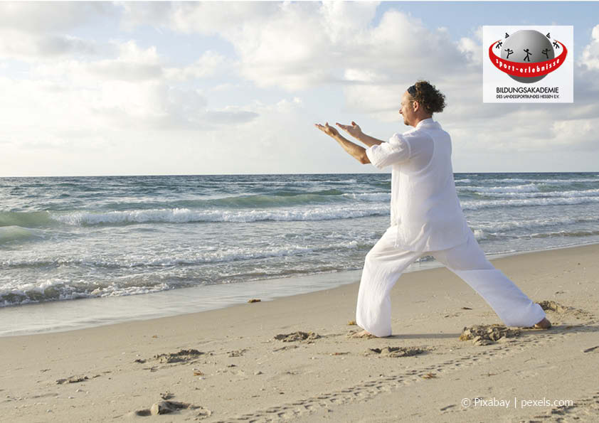 Ein Mann praktiziert Qigong am Strand Achtsamkeit Entspannung Work-Life-Balance Bildungsurlaub